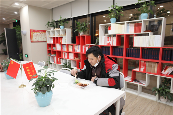 意外滯留在園區(qū)內(nèi)的快遞小哥收到了青年志愿者送來(lái)的一份熱騰騰晚餐，讓這個(gè)冬雪夜更暖心.jpg
